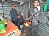 Soğuk havaya karşı soba yakarak müşteri bekliyorlar